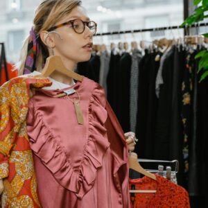 Young woman explores dress options in a stylish boutique.