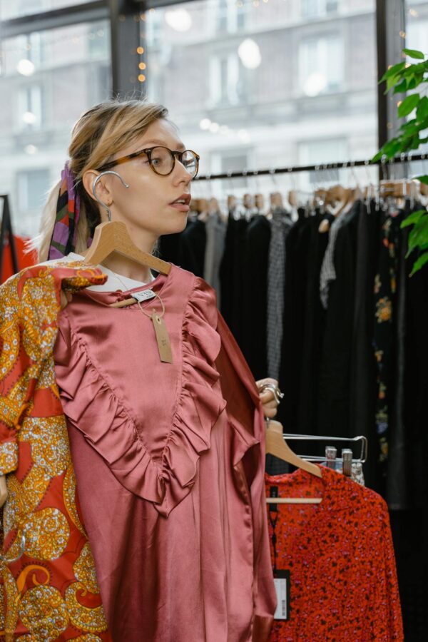 Young woman explores dress options in a stylish boutique.